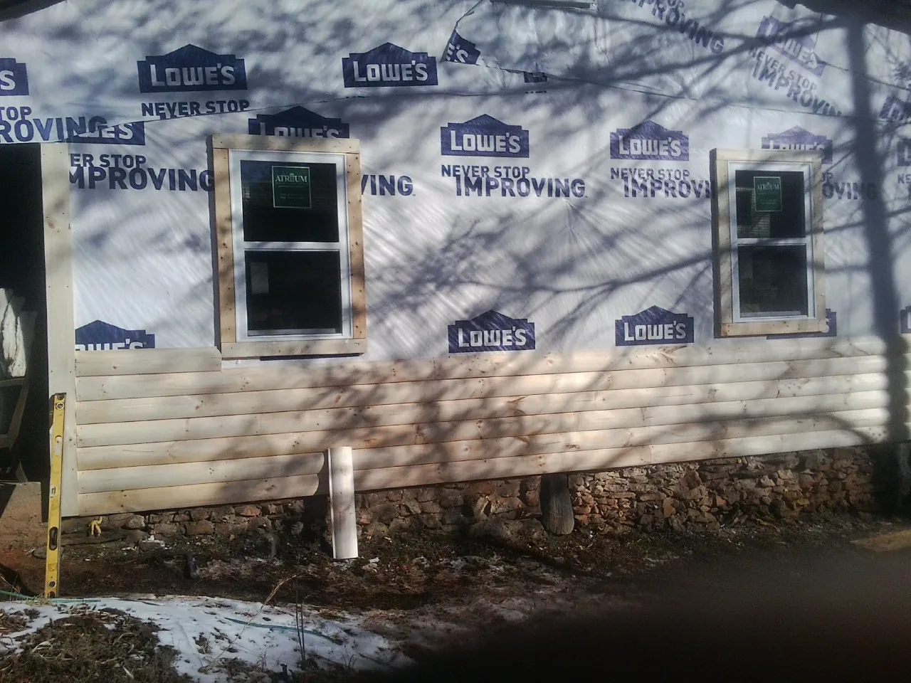 House wrap and new log siding going up on an exterior wall in Pine Bush