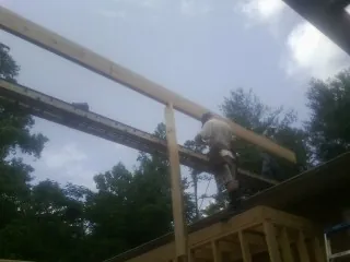 Carpenter setting a ridge beam over a new addition frame — Ice Dam Removal by Roofing Brothers in Pine Bush