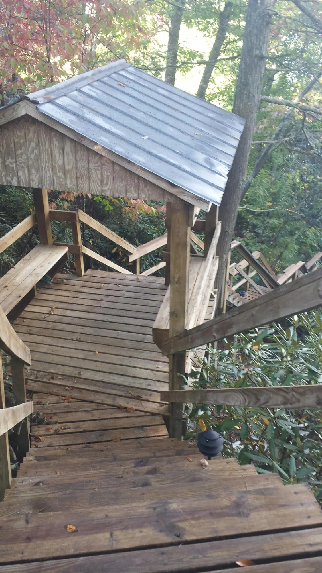 Metal roofed shelter over wooden steps on a wooded walkway — Skylight Repair & Installation work by our crew in Pine Bush